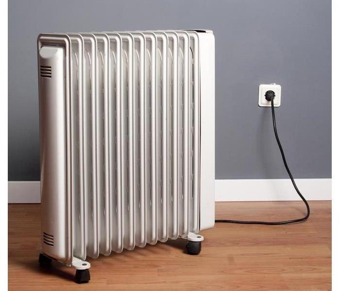 white space heater up against grey wall on light brown wood floor