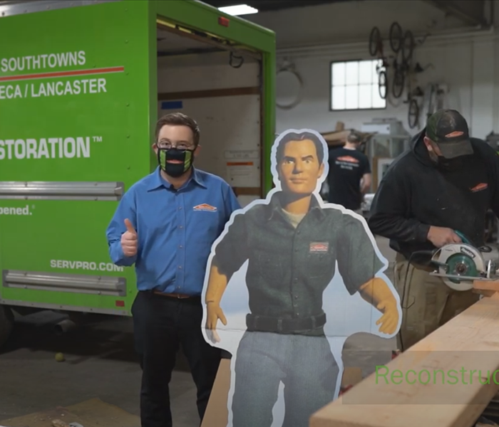 Dan from SERVPRO with a Blaze cardboard cutout giving the thumbs up in front of the reconstruction team.