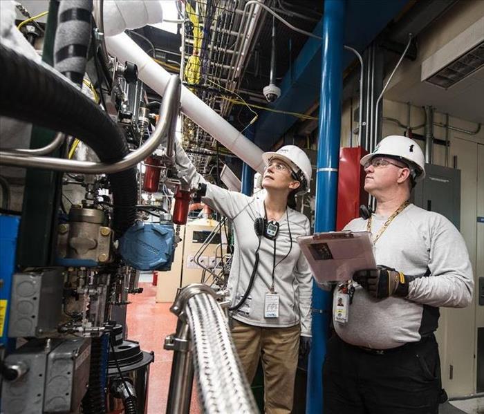 Female engineer and male engineer inspecting equipment at a Thermochemical User Facility Pilot Plant.