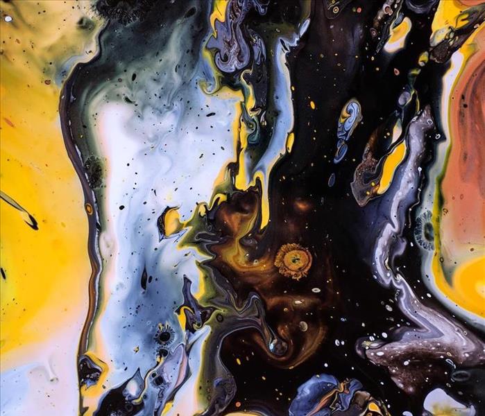 Abstract black and yellow painting with waves and blobs of paint.