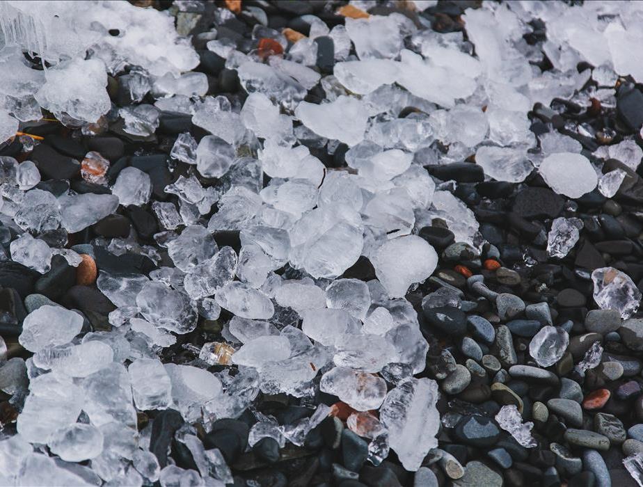 Hail stones melting on a rocky beach.