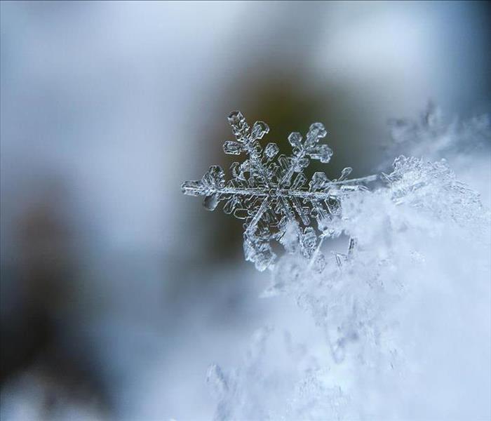 Focused picture of a single snowflake, close up.